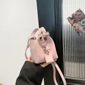 Rosa Mini-Eimertasche mit Litschi-Muster, Tragegriffen und schmalem Umhängeriemen - Rosa