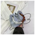 Bolso saco azul claro con asa de perlas blancas y cadena de cuentas ámbar con textura de mármol - Talla única / Azul
