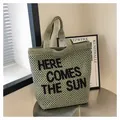 Detaillierte Nahaufnahme einer grünen Web-Tote-Bag mit Here Comes The Sun Stickerei - Einheitsgröße / Grün