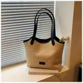 Detail der handgewebten Stroh-Tasche mit schwarzen Ledergriffen und FASHION-Logo - Einheitsgröße / Schwarz