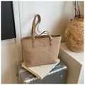 Detailaufnahme der Stroh-Tragetasche mit Kunstlederbesatz und Markenlogo-Patch im Fokus - Mit Anhänger / Khaki