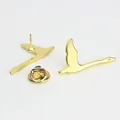 Detalle de broches de aves en metal dorado con acabado pulido y cierre de mariposa - Estilo Cisne Volador (A00011)