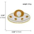 UFO-emaille pin in wit en oranje met afmetingen en gewichtsinformatie op wit - A00205.