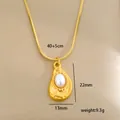 Detalle de colgante de corazón bañado en oro con perla sobre fondo de seda - Estilo Vintage Perla de Lágrima (C-1-38)