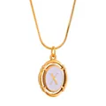 Detailed close-up of gold titanium necklace with oval enamel pendant featuring letter X - Letter X