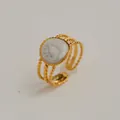 Détail macro d'une bague dorée ajustable avec incrustation marbre blanc et triple anneau - Style Bord Dentelé Rond Vintage (233) / Or