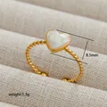 Close-up of golden rope band ring featuring a 8.5mm marble-textured heart charm - Twisted Rope Heart Style (243) / Gold/White