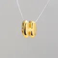 Macro detail of high-polished gold-plated bubble letter H pendant for DIY jewelry - Letter H