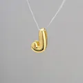 Macro shot of 3D balloon letter J pendant in gold finish with mirror polished surface - Letter J