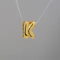 Detailed view of balloon-style letter K pendant in polished gold finish and shiny metal - Letter K