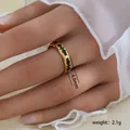 Detalle del anillo de titanio dorado de 4,8 mm con patrones de esmalte negro en la mano - Estilo de Patrón Simétrico de Esmalte Negro