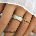 Detail view of 8mm gold wavy ring with white pearl texture showing 3.9g weight - Pearlescent Wave Finger Ring (239) / 8mm