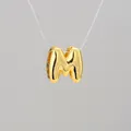 Macro shot of 18K gold plated bubble letter M pendant with high polish metal finish - M