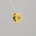 Macro detail of gold-plated hollow H-shaped pendant with a polished shiny finish - Letter O