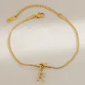 Detail van gouden knoop slangenketting armband met glinsterende letter R op zijde - Letter R