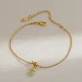 Detail van gouden slangenketting armband met sprankelende strass letter S hanger - Letter S