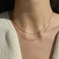 Close-up of double layer gold snake chain necklace on a white sweater model - Smooth Double Layered Snake Bone Chain Style (0.9 Square Snake) / Gold