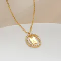 Vista macro de collar chapado en oro con colgante ovalado hueco y letra A de circón - Letra A