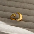 Detalle macro de anillo ajustable de estrella y luna dorada sobre soporte beige - Estilo Dorado (209)