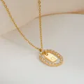 Dettaglio della collana placcata oro con pendente ovale, zirconi e incisione lettera G - Lettera G