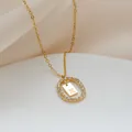 Dettaglio macro della collana dorata con anello in zircone e pendente con lettera X - Lettera X