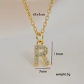 Macro shot showing dimensions of letter R pendant with cubic zirconia and gold chain - Letter R
