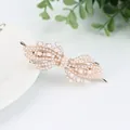Pink pearl bow hair clip with rhinestones on a white ceramic plate background - Orchid