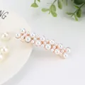 Elegant gold metal hair clip with tiered white pearls in a multi-layered design - Linear