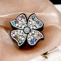 Pince à cheveux élégante en forme de fleur avec des strass colorés sur fond noir brillant - Coloré