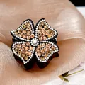 Elegant black hair claw with champagne crystal four-leaf flower and white rhinestone center - Champagne