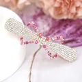 Sparkling pink rhinestone bow hair clip with rose gold plating on elegant display stand - Red Bowknot