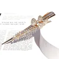 Golden butterfly hair clip featuring rhinestone tassels on a minimalist white background - Double Bow Style / White