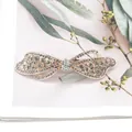 Elegant gold hollow bow hair clip with sparkling rhinestones and iridescent crystals - White With Printed Ribbon