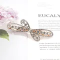 Elegant gold butterfly hair clip with sparkling rhinestones and hollow wing design - Flying Flower White