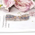 Elegant rose gold bow hair clip featuring blue and white rhinestones on a magazine background - Blue Bowknot