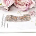 Elegant rose gold bow hair clip adorned with sparkling rhinestones on a pink floral background - White Bow