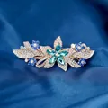 Floral hair clip with green rhinestone center and blue crystals on gold base - Star Blue