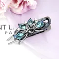 Blue flower hair clip with crystals and black gemstone on a purple background - Peacock Blue