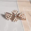 Pince à cheveux nceud dorée ornée de perles blanches et de cristaux scintillants - Pétale de Perle