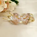 Elegant gold butterfly hair claw clip with champagne crystals on a beige satin background - Yellow