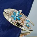 Elegant gold flower hair clip with blue rhinestones and sparkling crystal accents - Blue