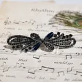 Vintage gunmetal hair clip with deep blue gemstones and dark rhinestones on sheet music - Gun Black Blue Flower