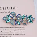 Pince à cheveux dorée ornée de fleurs et papillons en strass bleus et verts - Papillon Bleu
