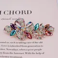 Barrette papillon fleurie avec cristaux colorés et finition dorée sur fond rose - Papillon Multicolore