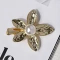 Eleganter goldener Blumen-Haarclip mit Hammerschlag-Optik und einer großen weißen Perle - Gold