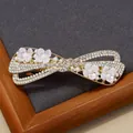 Fermaglio per capelli a fiocco dorato con strass bianchi, perle e fiori in madreperla - Stile Wusi