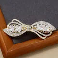 Elegante fermaglio a fiocco dorato con strass, perle e fiori bianchi su base scura - Stile Jindai