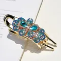 Elegante pinza per capelli dorata con strass blu e bianchi a forma di fiore e farfalla - Blu
