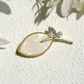 Elegant leaf-shaped shell brooch with gold edging and small pearl accents - Magnolia Leaf