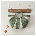 Detalle de bolso de paja tejido con rayas verde y beige con detalles de hilos dorados finos - Talla única / Verde